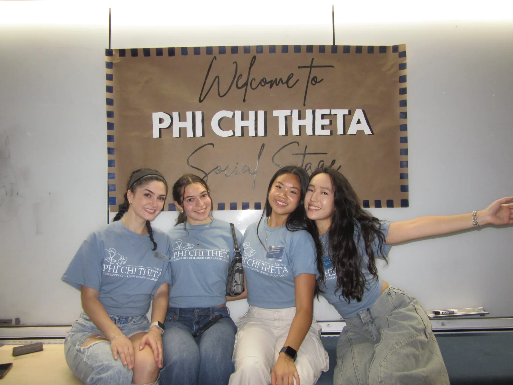 Three PCT members beside the Phi Chi Theta welcome sign